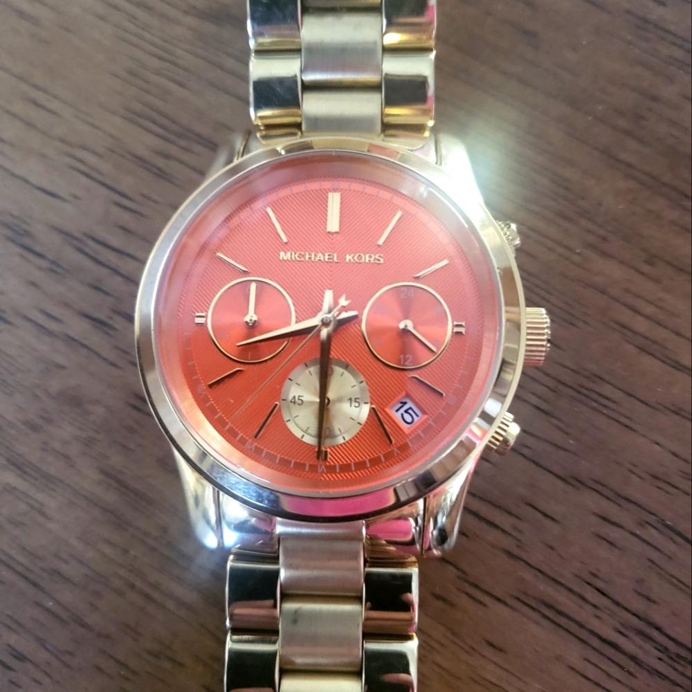 Micheal Kors watch 32 mm. Orange watch face. Paid $375.00, never wore watch.
